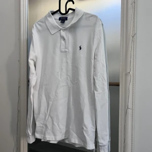 Polo Ralph Lauren - Säljer en riktigt snygg och fräsch långärmad polo Ralph Lauren piké i knappt använt skick! Den har mest legat i garderoben då klädstilen förändrades. Ser lite sliten ut på bilderna men behöver bara strykas vilket görs innan postningen till högst bjudande!