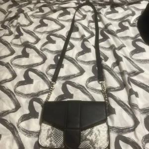 Axelväska  - Svart/vit axelväska. Ser alldeles ny ut och har typ aldrig använt den. Jättefin väska men har en annan