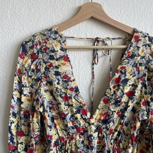 Blommig klänning - Klänning från H&M. Djup både framtill och i ryggen. Mycket fint skick!