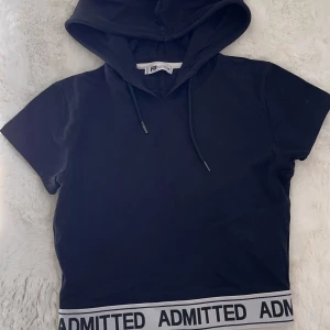 Tshirt  - En svart tshirt med en luva i storlek M men sitter som ett S