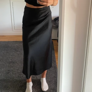 Satin kjol - Svart satin kjol med slits från Bik Bok i storlek XS. Använd fåtalet gånger men är fortfarande i fint skick!💛