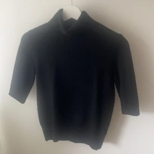 Stickad tröja  - En jättefin stickad tahirt i svart! Jättefint skick! 