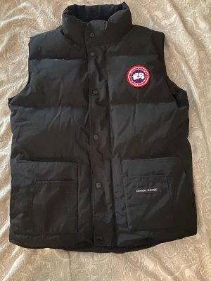 Canada Goose Väst - Säljer en canada goose freestyle väst i nyskick, storlek XS passar folk som är 160-175cm långa. Använd 1 gång. Köpt ifrån johnells för ca 5000kr (kvitto finns).