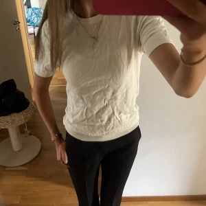 Finstickad t shirt - Säljer denna snygga T-shirt i en krämvit färg, med knappar bak i nacken💛strl 34/36 150kr 