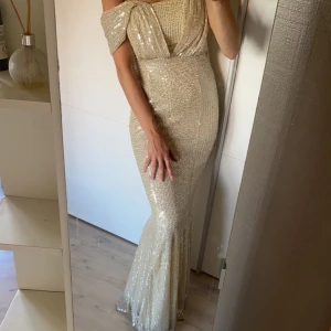 Festklänning/ balklänning - Fest/bröllop/bal-klänning. Den är guld glittrig,  använd någon enstaka gång. 