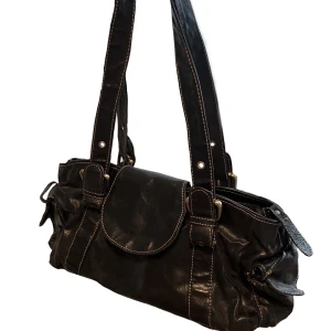 medelstor skinnväska - medelstor svart skinnväska med mycket utrymme! Fickor på bägge sidor av väskan perfekta för t.ex. plånbok eller nycklar. Fungerar bra att ha över axeln med justerbara band🫶