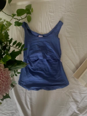 Ljusblått amnings linne - Ljusblått amnings linne. Går att dra upp den övre delen över bröstkorgen. 