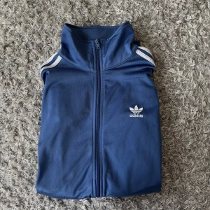 Adidas kofta - Blå adidas kofta🤍väldigt bra skick. Oversized och väldigt skönt material! 