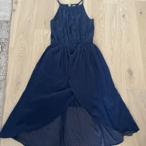 Mörkblå klänning  - En mörkblå klänning i jätte bra skick med fantastiskt fin nederdel som har lite lättare tyg som fladdrar i vinden.