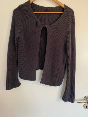 Fin kofta med spänne - Fin vardagskofta med spänne vid halsen. Stickad i en randig struktur i bra kvalitet.