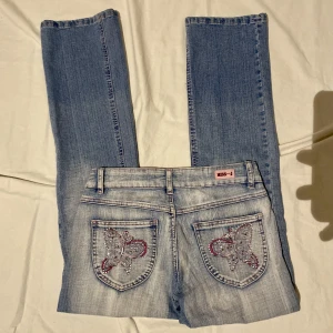 Fjärils jeans - Bra skick. Lågmidjade  Midja: 34,5cm Lår: 24cm (elastiskt tyg) Skrev mått: 15cm Innerbenslängd: 72cm Benöppning: 19cm