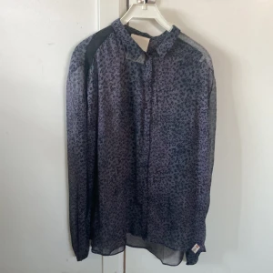 Genomskinlig leopard blus - Jätte fin genomskinlig blus med leopard mönster. Svart och svagt rosa med svarta smala revärer på axlarna. Bra skick, bara använd några få gånger. Stl M-L