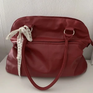 Röd handväska  - (Första bild lånad)handväska köpt här på plick i superfin vinröd färg, perfekt nu till hösten och vintern. Får plats med mycket och går att ha som skolväska, då både böcker o dator får plats. Väldigt bra skick. Skriv för fler frågor! Använd gärna köp nu!💕