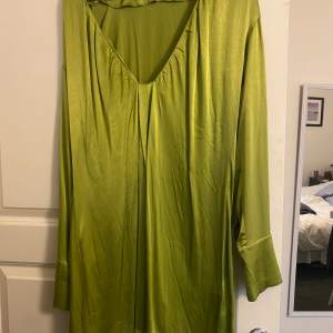 En grön silkesklänning från NAKD i storlek 38. Aldrig använd pga inte min stil. 