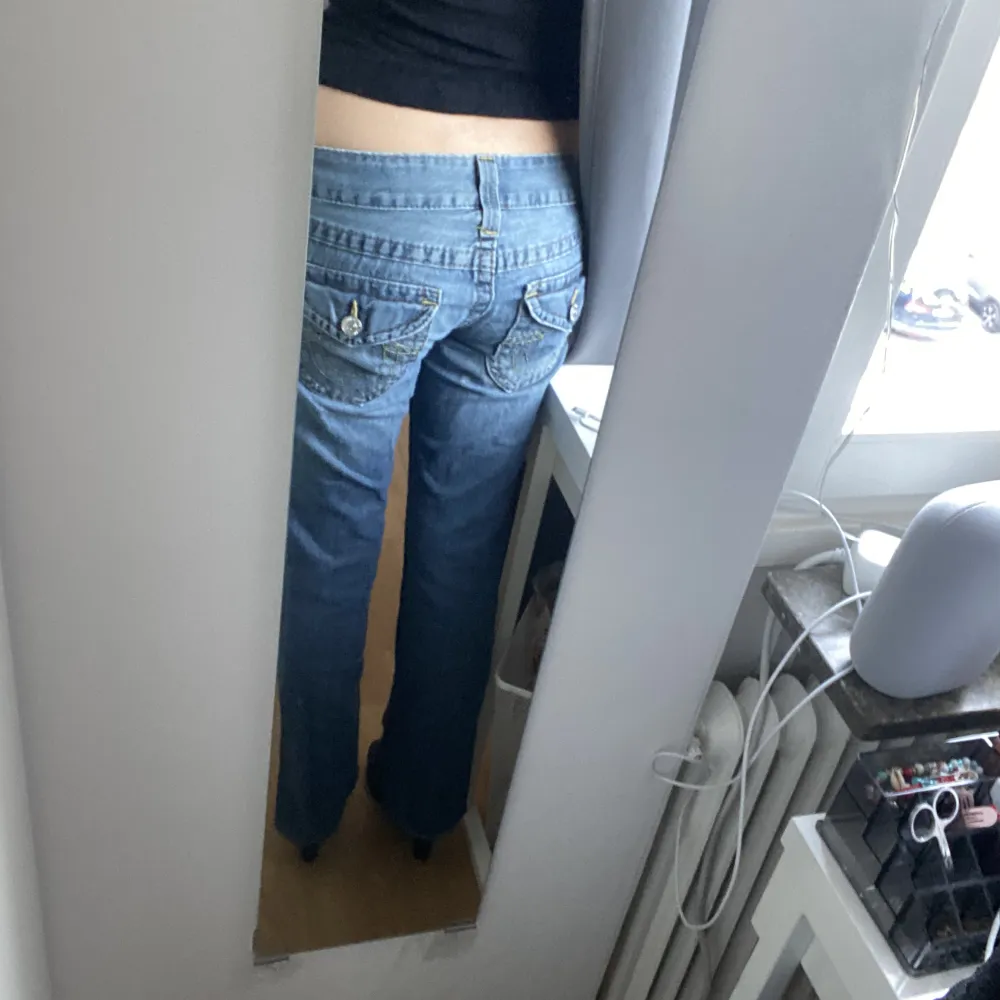 Ett par utsvängda, lågmidjade true religion jeans som jag köpt på en secondhand i Danmark för cirka 800kr. Jag har fått dom uppsydda och dom är litet slitna men själv har jag knappt använt dom. Dom är lite stora i midjan men passar mig som är S och 163🤩🥰. Jeans & Byxor.