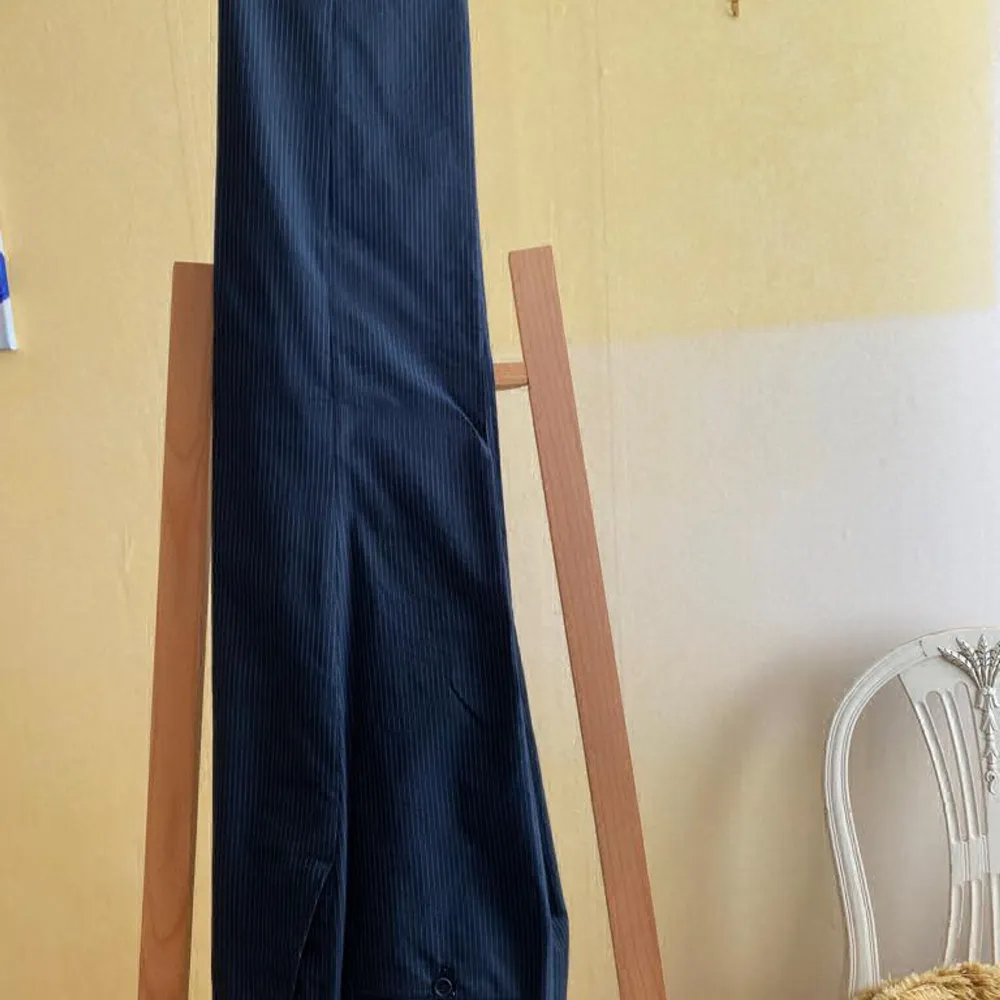 Mörkblå kritstecksrandig herrkostym av märket Jerem.  Storlek: 48 (för en person ca 185 cm) Kavaj: längd 79 cm, axelbredd 43cm, ärm 64cm. Byxa: sidolängd 106,5 cm, midja 82 cm.  Använd en gång. Som ny.. Kostymer.