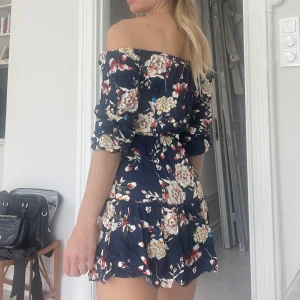 Blommig off shoulder klänning - Superfin klänning med blommor  Band i midjan Använd en gång Storlek 36 men jag är S och den är ganska liten på mig då jag är bredaxlad 