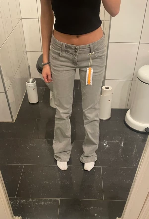 Low flare jeans - Gina Tricot - Slutsålda ljusgrå low flare jeans från Gina Tricot! Helt oanvända, lappen sitter kvar. Jag är 156 och de är för långa på mig! Köpta för 350kr. Köparen står för frakten💗