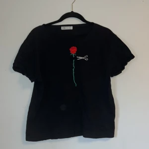 Svart T-shirt med ett designat hål - T-shirt som aldrig använts och är väldigt fin.