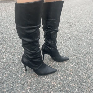 Stövlar - Stövlar med smal klack och spetsig framme vid tårna. Svart fakeskinn. Passar till ALLT!