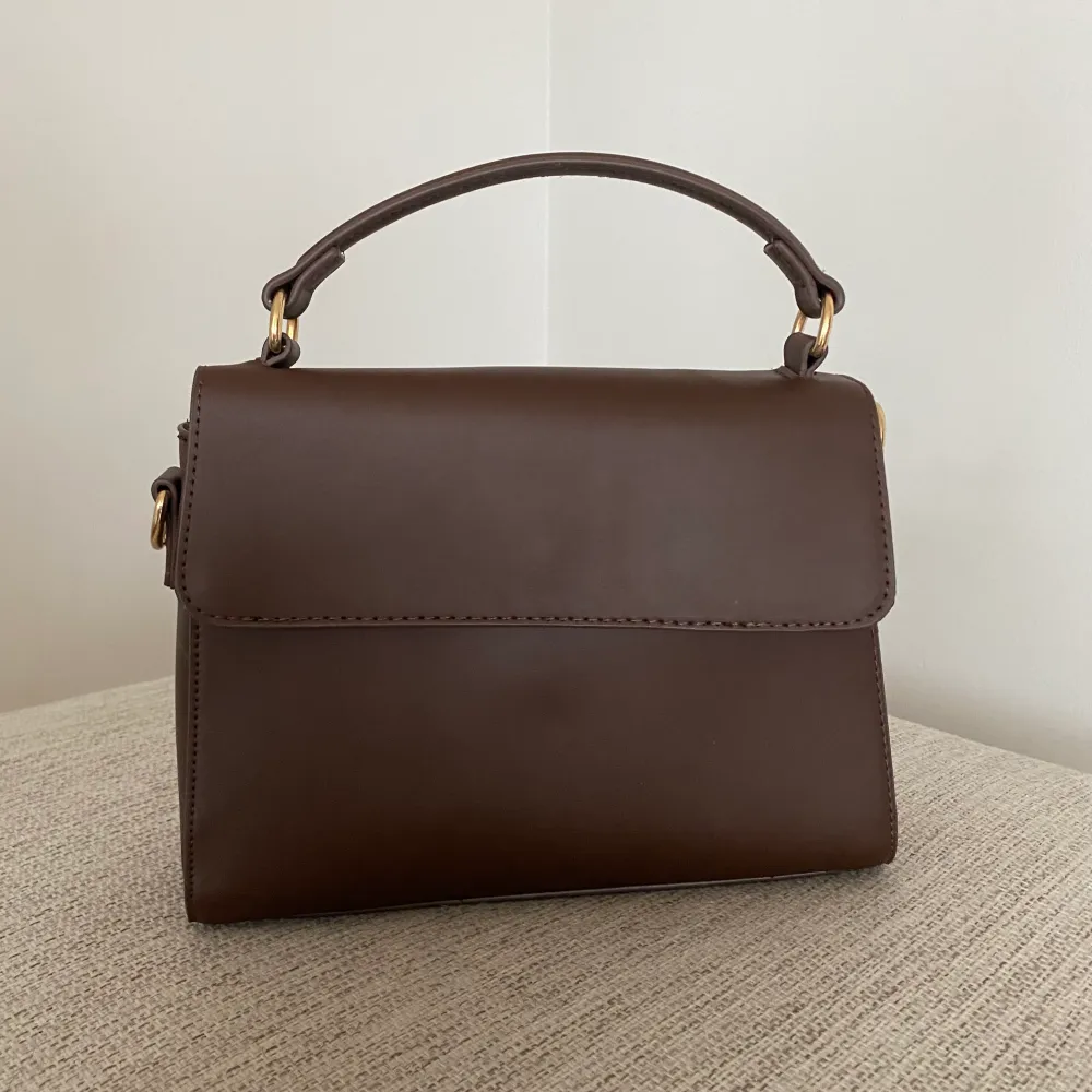 Säljer denna handväska i en nyans av brun. Ett större fack och två mindre. Frakt tillkommer💕. Väskor.