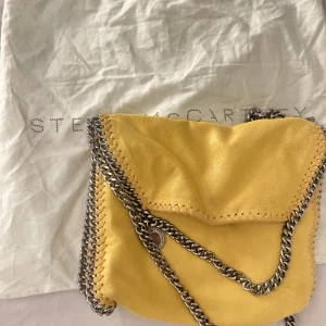 Stella McCartney väska - Säljer nu min superfina gula stella McCartney väska, pga att jag inte använder tillräckligt mycket😫 den är i jättefint skick, inga kedjor som är rostiga osv. Skriv för mer info. 