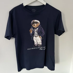 POLO Bear Ralph Lauren T-Shirt - Jag säljer min POLO Bear Ralph Lauren T-Shirt i bra kvalitet. Den är i storlek L men sitter som storlek M. Säljer den då den är för liten för mig.  Skriv för mer bilder!!
