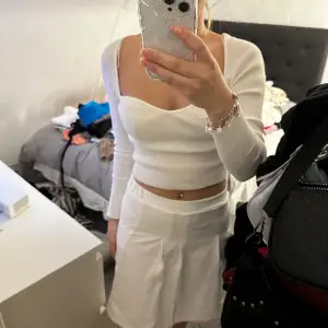 En vit lite längre kjol. Aldrig använd därav bra skick 
