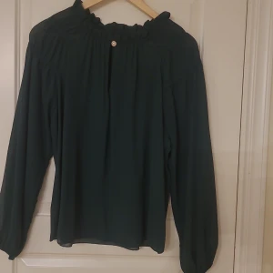 Grön blus - Helt ny grön blus med pärlknapp och vackra detaljer runt kragen. 