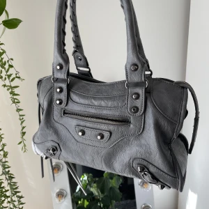 Balenciaga liknande väska - Säljer min så snygga mellanstora balenciaga liknande väska. Väskan är tidigare köpt här på plick, och är i nyskick bortsett från dragkedjan på ytterfacket 💕Det finns även ett tillhörande axelremsband. (obs. bild 2 är lånad). 