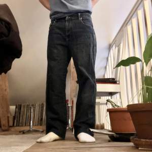 Marineblå loose jeans, har lite vit färg på ena byxbenet