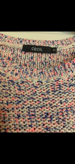 Jätte fin tröja från CECIL. St: M. - Flerfärgad stickad  tröja från Cecil: ljusblå, puder rosa och créme. Mått: från ärmhåla till ärmhåla: 2 x 49 cm. Från ärmhåla till nederkant: 40 cm.  Skick: mycket fint. Skickas m Post Nord spårbart: 60 kr.