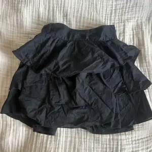 Säljer min svarta volang kjol, perfekt till sommaren! Sitter jätte fint oc har ett luftigt material i någon linne blandning.