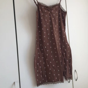 Klänning - Jättefin klänning med små rosa blommor på. Har en liten slit längst ner åt vänster. Aldrig använd pga att den är för stor.