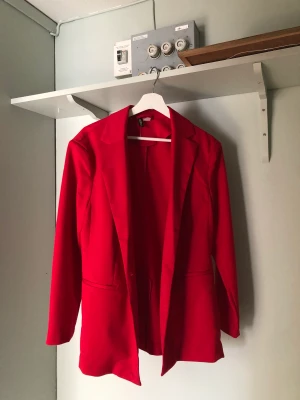 Röd kavaj - Röd lite oversized kavaj. Den har ett hål vid sömmen på axeln, inget som egentligen är så synligt. Använt fåtal gånger. 💛