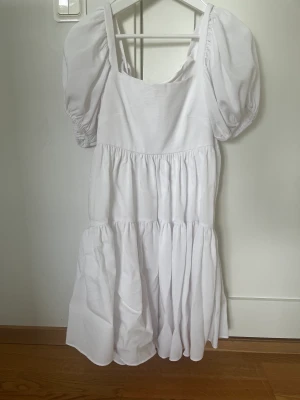 Vit klänning - Superfin vit klänning med knyte i ryggen från BikBok som skulle passa till skolavslutning.