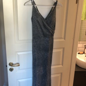 Glittrig långklänning - superfin, silvrig långklänning som sitter snyggt på! den glittrar verkligen jättefint i verkligheten ✨ säljer för att den var för kort, som man kan se på bild nr 3. jag är 174 cm. prislappen är kvar, aldrig använd!! kan frakta inom kort 👍