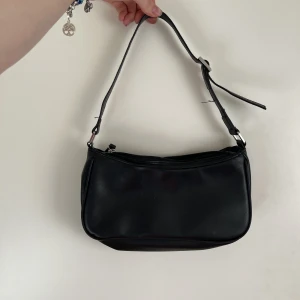 Svart väska - Liten svart axelväska från monki, knappt använd säljer då den inte kommer till användning😊