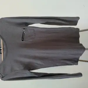 Gray top with zipper pocket and a zipper decoration on the shoulder 