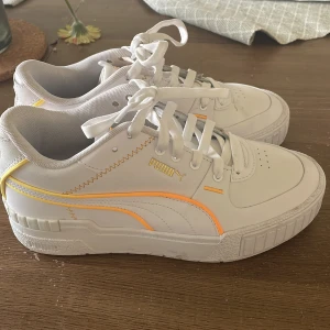Puma sneakers - Vita och orangea sneakers från puma, använda 1 gång