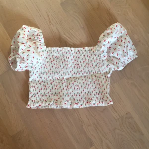 Topp - En topp med körsbär dekoration. Säljer den pågrund av att den är för liten. Använd Max en gång. XS