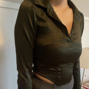 Glossy material topp - Cropped topp i khaki färg från Zara. Använd enstaka gånger så varan är inte väldigt bra skick. Storlek S