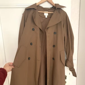 Trench - Så svårt att fånga den här trenchcoaten på bild men jättefin😵‍💫Aldrig använd av mig då det tyvärr inte riktigt är min stil