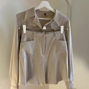 Tvådelat set - Set i beige från FREE Paris (vintage)  Storlek XS/S - som 36 95% Polyester 5%Elastan  kjol+skjorta 450kr