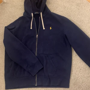 Ralph lauren tröja - Polo Ralph lauren zip up tröja i storlek XL har lite missfärgningar men syns knappt kan skicka bättre bilder på det privat mörk blå med gul låga