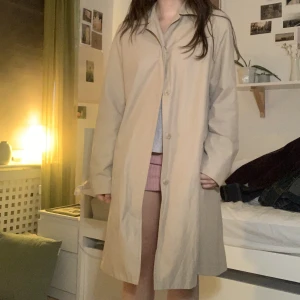 Hennes trenchcoat  - Beige trenchcoat, slutar lite under knäna på mig som är 162cm. Finns ett bälte för att knyta runt midjan också. 