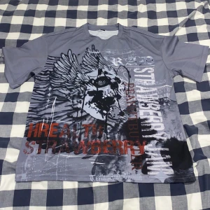 En grå t-shirt. - En grå t-shirt med en dödskalle på, har aldrig använts och har väldigt bra material. Den är lite oversized.