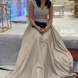 Bal/Bröllops klänning - köpt från proms&weddings i malmö, jätte vacker silver/glittrig klänning, använt den 2 ggr. skulle säga att den är storlek XS/S, köptes för 2k. är 166 & är bra längd med klackskor!