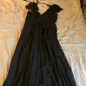 Lång balklänning  - En lång balklänning köpt från Nelly för något år sedan, endast använt en gång så i nyskick! Väldigt fina spets detaljer i ryggen där man även knyter klänningen. St 34 - passar mig som är 170cm ner till fötterna. 