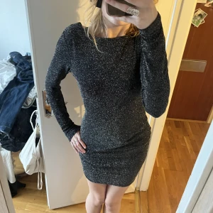 Glittrig festklänning - Långärmad svart glittrig klänning med öppen rygg. Så bra till tex nyår. Skriv om ni vill ha fler bilder eller undrar något. Skriv gärna innan till mig innan du köper 💕